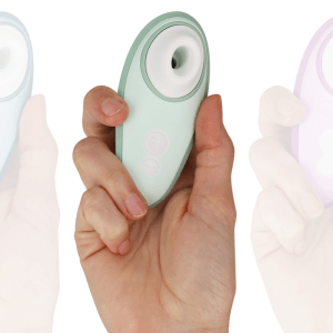 Petit vibromasseur sans fil tenu dans une main, détail bouton et tête arrondie, fond blanc.